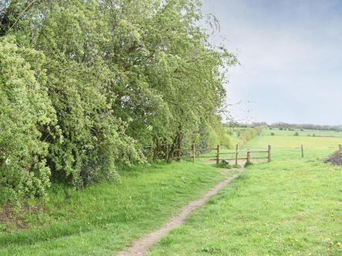 a dirt road in a field next to a fence at White Heather Barn in Swanwick