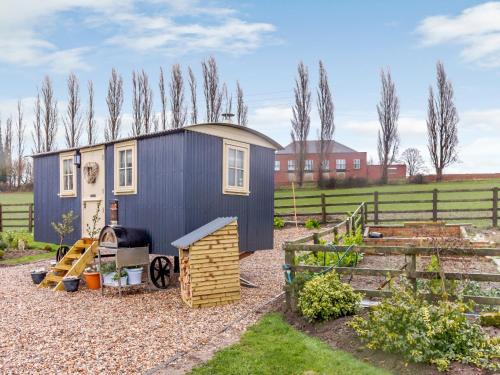a tiny house in a garden with a fence at The Lambing Shed in Ryhill
