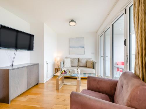 a living room with a couch and a tv at Pegasus in Falmouth