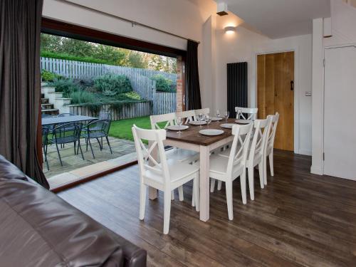 a dining room with a table and white chairs at Willow Barn - Fernhill Farm in Wootton Bridge