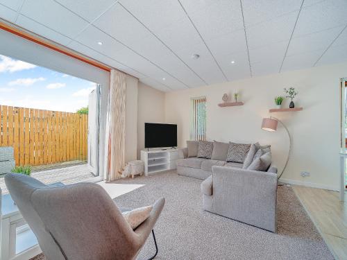 a living room with a couch and a tv at 1 Ladyknowe - Uk39970 in Moffat