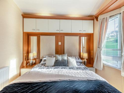 a bedroom with a large bed with white cabinets at Hafod Caravan - Uk45717 in Brynteg