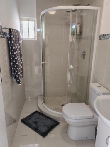 a bathroom with a shower and a toilet and a sink at Marula Guest House Unit 1 in Durban