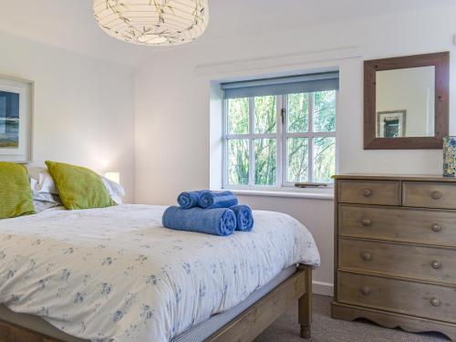 a bedroom with a bed with blue towels on it at No Place in Sennen