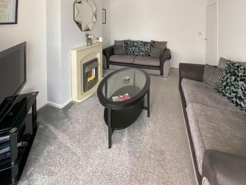 a living room with a couch and a glass table at Coleridge Lodge in Thornton