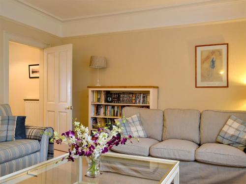 a living room with a couch and a table with flowers at Linton in Keswick