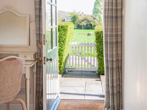 an open door to a garden with a horse in the yard at The Gatehouse Cottage in Wells