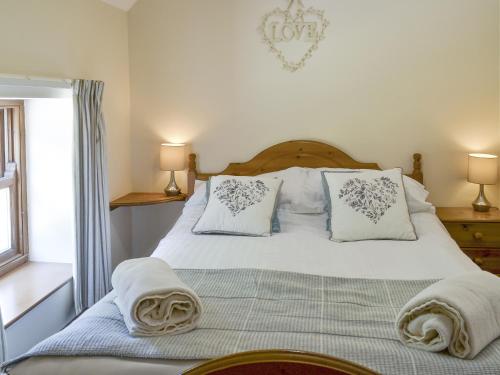 a bedroom with a bed with white sheets and pillows at Clydesdale Cottage in Sewerby