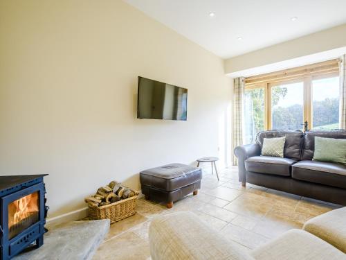 a living room with a couch and a fireplace at Horseshoe - Uk30759 in Bream