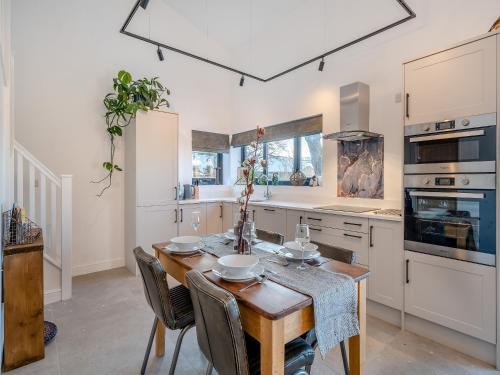 a kitchen with a wooden table with chairs and a dining room at Moorgate Lodge - Uk47742 in Kelbrook
