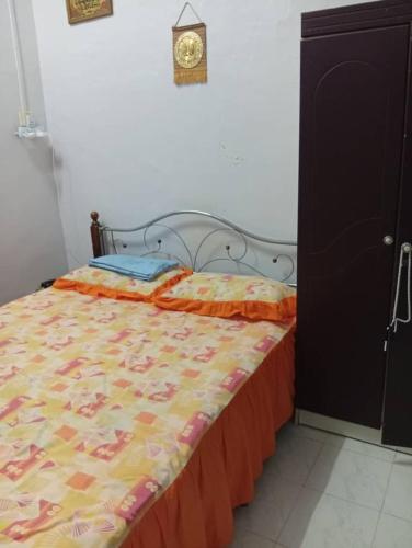 a bed in a bedroom with a clock on the wall at Rumah Inap ABC in Pasir Mas