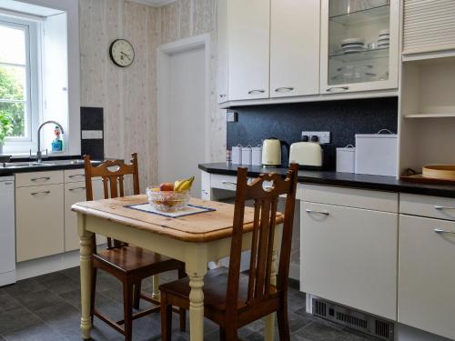 a kitchen with a table with chairs and a counter top at Craigvar House in Castle Douglas