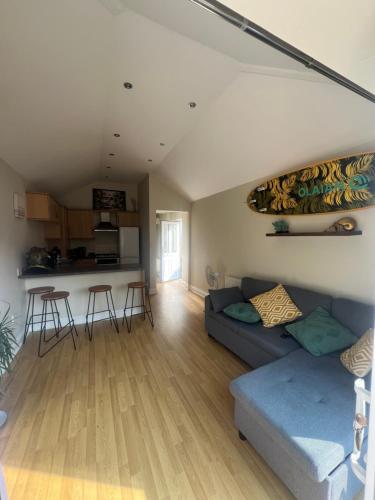 a living room with a couch and a kitchen at Open plan flat with large garden close to beach in Bournemouth
