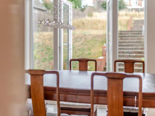 a dining room table with chairs in front of a window at Carey in Eastchurch
