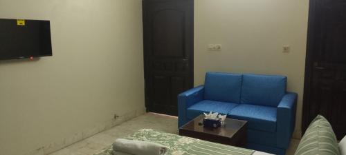 a living room with a blue couch and a table at Hotel White Palace Clifton in Karachi