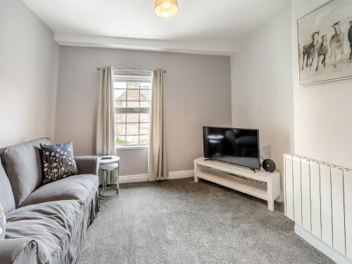 a living room with a couch and a tv at Bluebell Apartment - Uk42381 in Bridlington