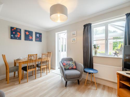 a living room with a table and chairs and a dining room at Pebbles in Overstrand