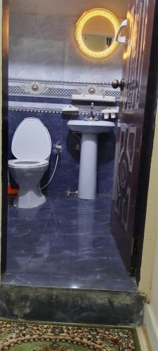 a bathroom with a toilet and a sink at Hotel White Palace Clifton in Karachi