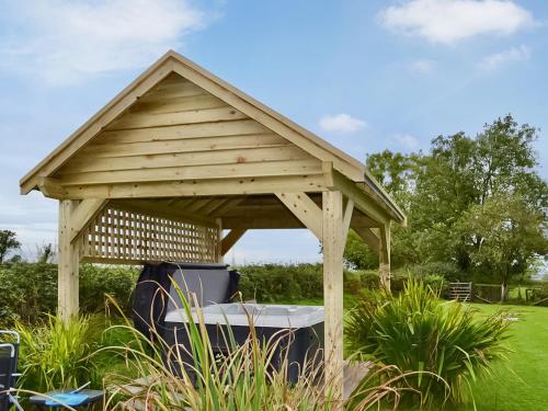 a wooden gazebo in the middle of a field at Angerton Cottage in Kirklinton