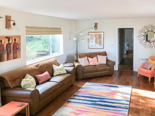 a living room with two brown couches and a rug at The Gallery in Mevagissey