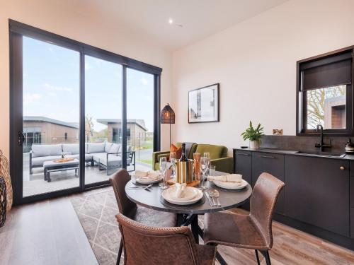 a kitchen and dining room with a table and chairs at Lodge One - Uk42796 in Llangefni