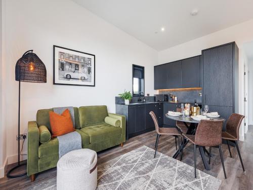 a living room with a green couch and a table at Lodge One - Uk42796 in Llangefni