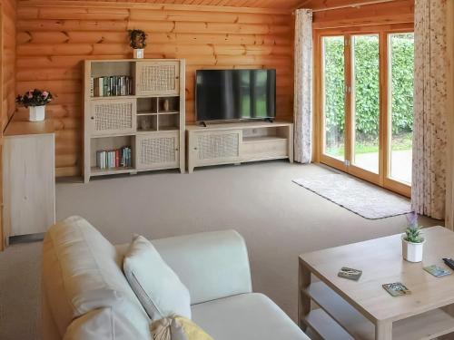 un soggiorno con un divano e una TV di The Lodge a Storrington
