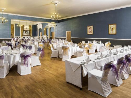 a banquet hall with white tables and chairs at Mercure Darlington King's Hotel in Darlington