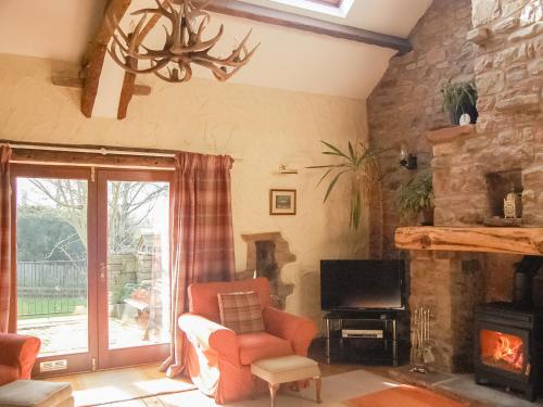 ein Wohnzimmer mit einem Stuhl und einem Kamin in der Unterkunft Garden Cottage in Pooley Bridge
