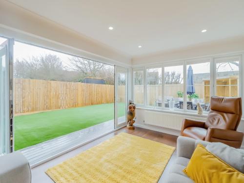 a living room with a couch and a large window at Chestnut House in Bridgend