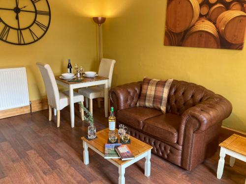 a living room with a couch and a table at Hollybank in Ladybank