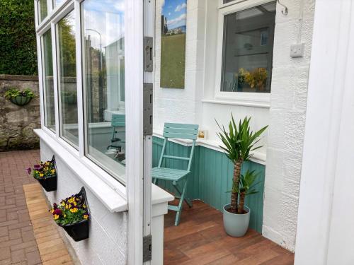 a small porch with a chair and a window at Hollybank in Ladybank