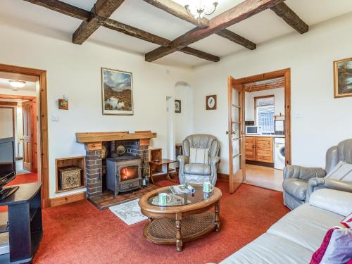 a living room with a fireplace and a table at Creagan Ruadh in Kintail