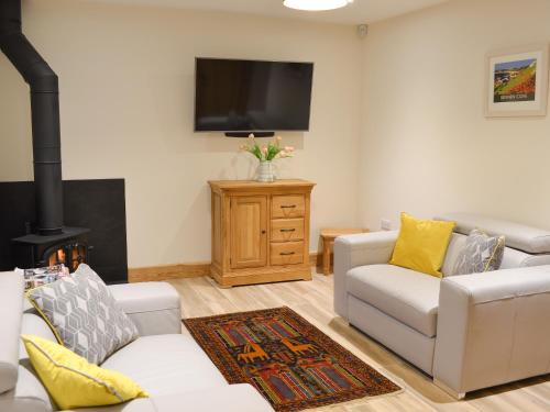 a living room with two couches and a flat screen tv at Chancer in Newlyn