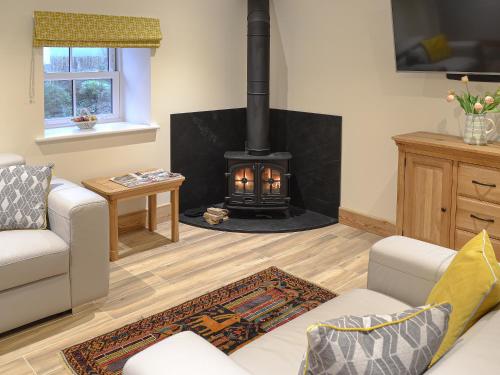 a living room with a fire place in the corner at Chancer in Newlyn