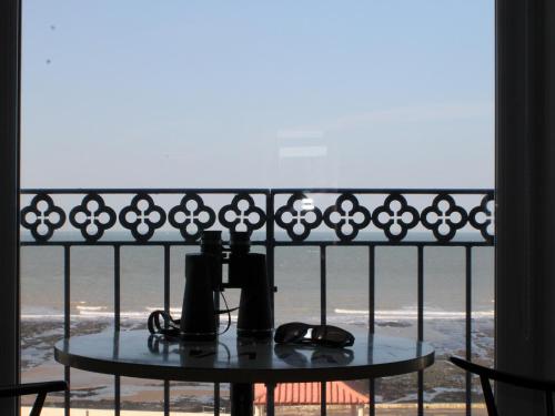 a table on a balcony with a view of the ocean at Dreamers View in Margate