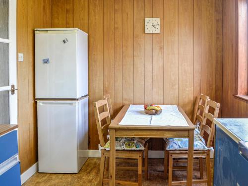 カッスル・ダグラスにあるArdencaple No 2のテーブルと冷蔵庫のある小さなキッチン