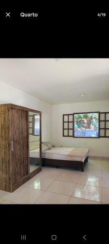 Un dormitorio con una cama grande y una ventana. en Casa sana beira rio, en Casimiro de Abreu