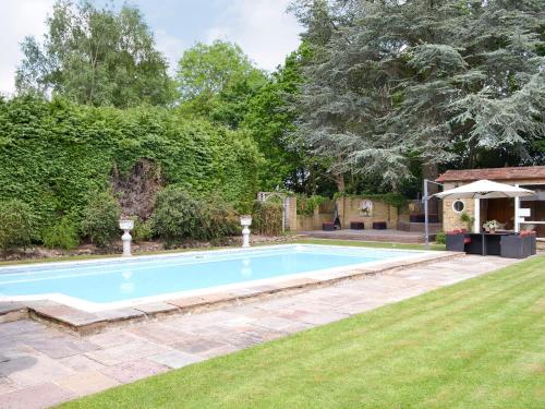 a swimming pool in the yard of a house at The Sanctuary in Little Chart