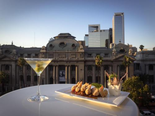 a table with a drink and some food on it at Mercure Santiago Centro in Santiago