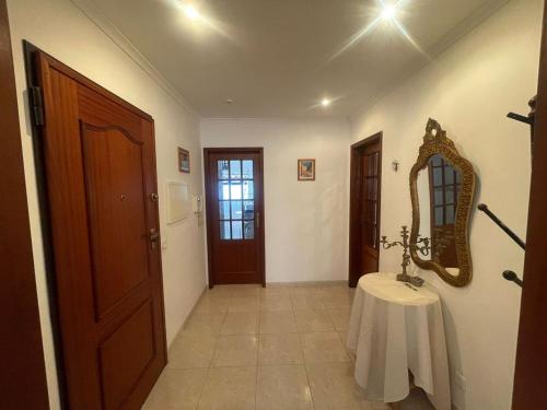 a hallway with a table and a mirror on the wall at Entire 3 bed rooms Apartment with Private wc ! in Samouco