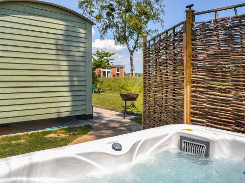 a tub in a backyard next to a building at Wildflower View in Lowthorpe
