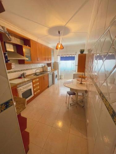 a kitchen with a table and a dining room at Entire 3 bed rooms Apartment with Private wc ! in Samouco