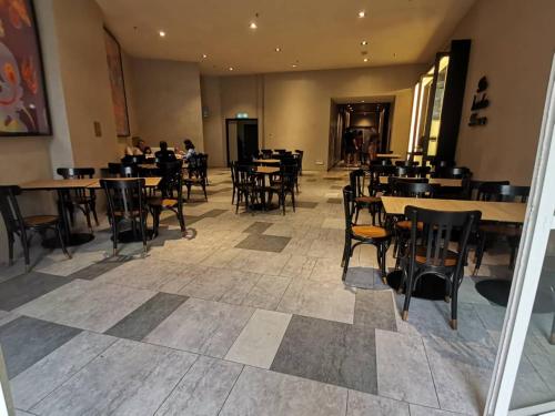 un comedor con mesas y sillas y personas sentadas en mesas en Windmill Upon Hills Genting Highland by El Naura, en Genting Highlands
