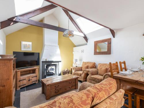 a living room with a couch and a tv at Cross Cottage in Saint Breward