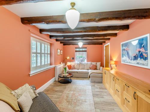 ein Wohnzimmer mit orangefarbenen Wänden und einem Sofa in der Unterkunft Cottage - Uk48472 in Lintz Green