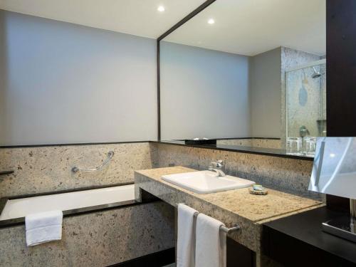 a bathroom with a sink and a mirror at Pullman Sao Paulo Vila Olimpia in Sao Paulo