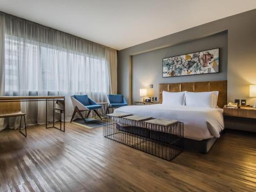 a hotel room with a bed and a desk at Pullman Sao Paulo Vila Olimpia in Sao Paulo