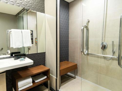 a bathroom with a shower and a sink at Pullman Sao Paulo Vila Olimpia in Sao Paulo