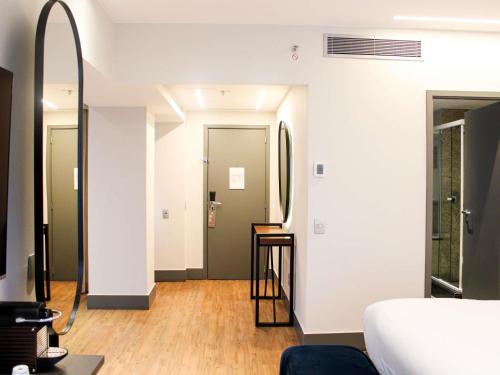 a room with a bed and a mirror at Pullman Sao Paulo Vila Olimpia in Sao Paulo